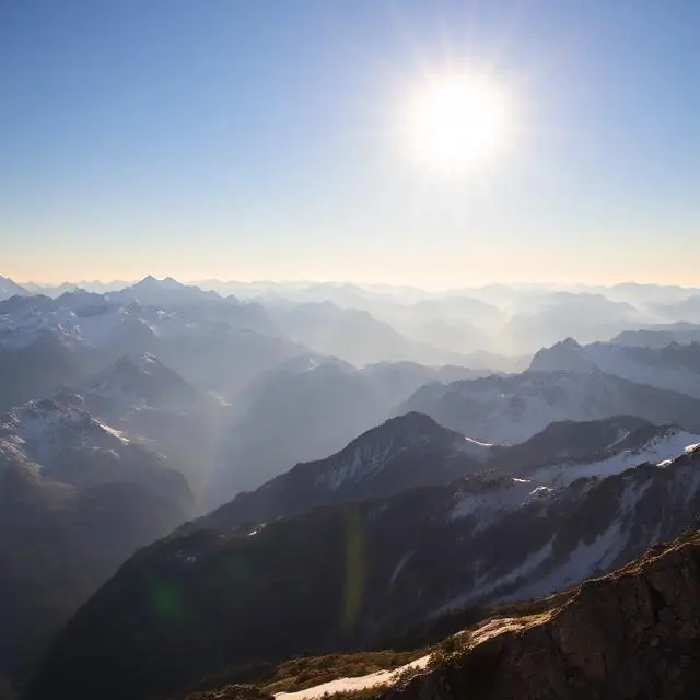 A breathtaking panorama of the sunlit Alps with snow-capped peaks.